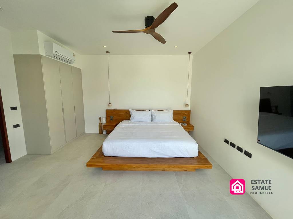 Bedroom with low wooden bed and ceiling fan
