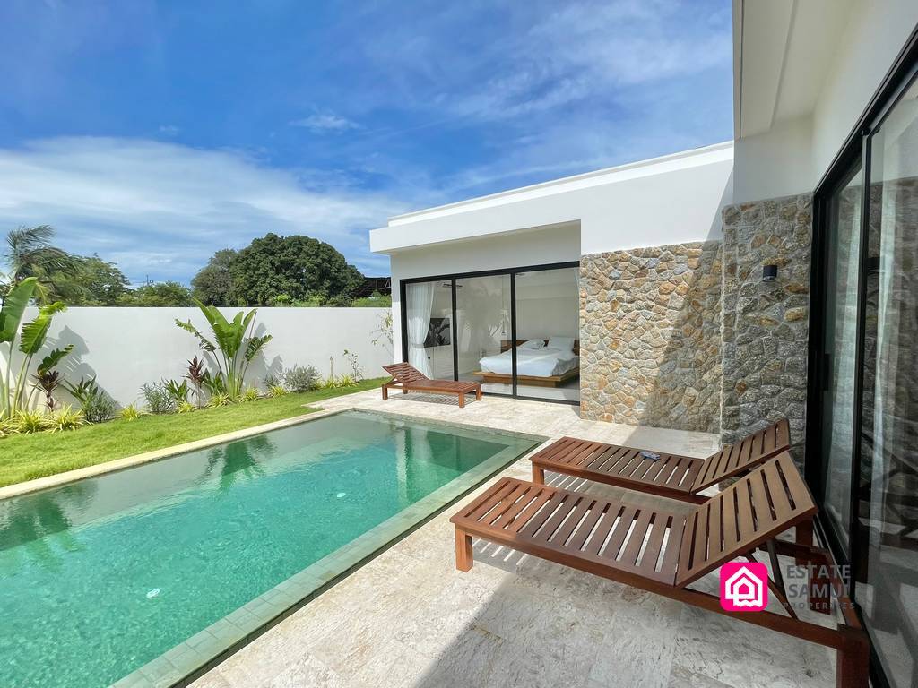 Poolside terrace with wooden loungers and stone-clad wall