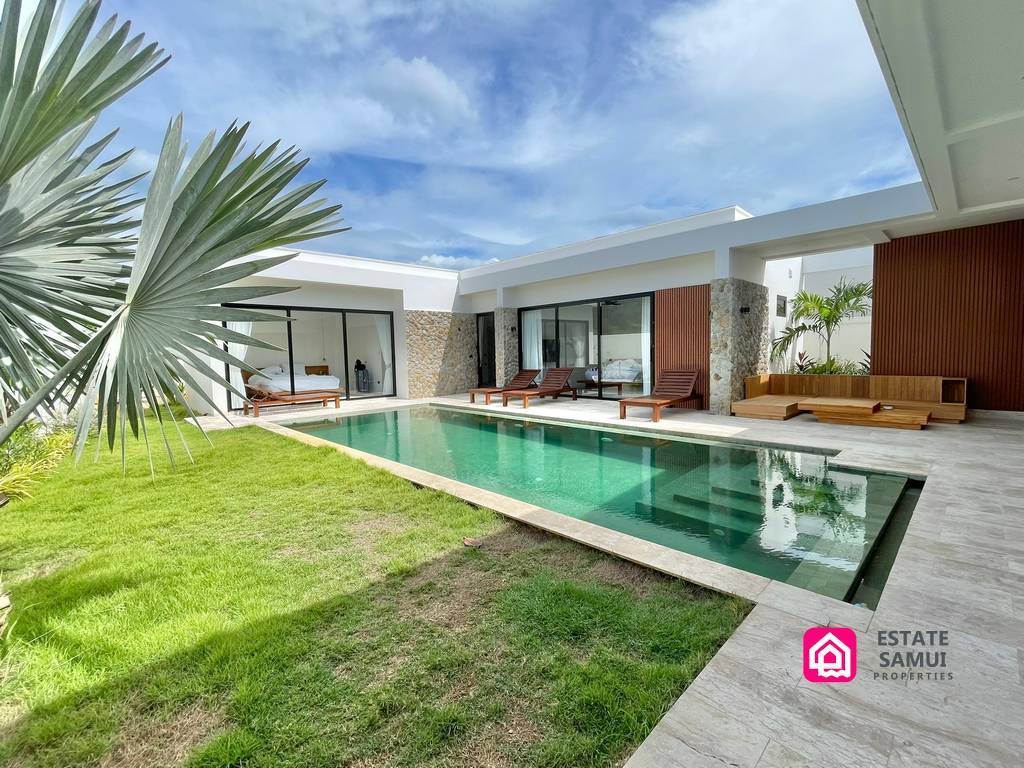 Lawn and swimming pool beside the white villa