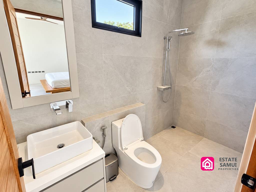 Tiled bathroom with walk-in shower and compact basin