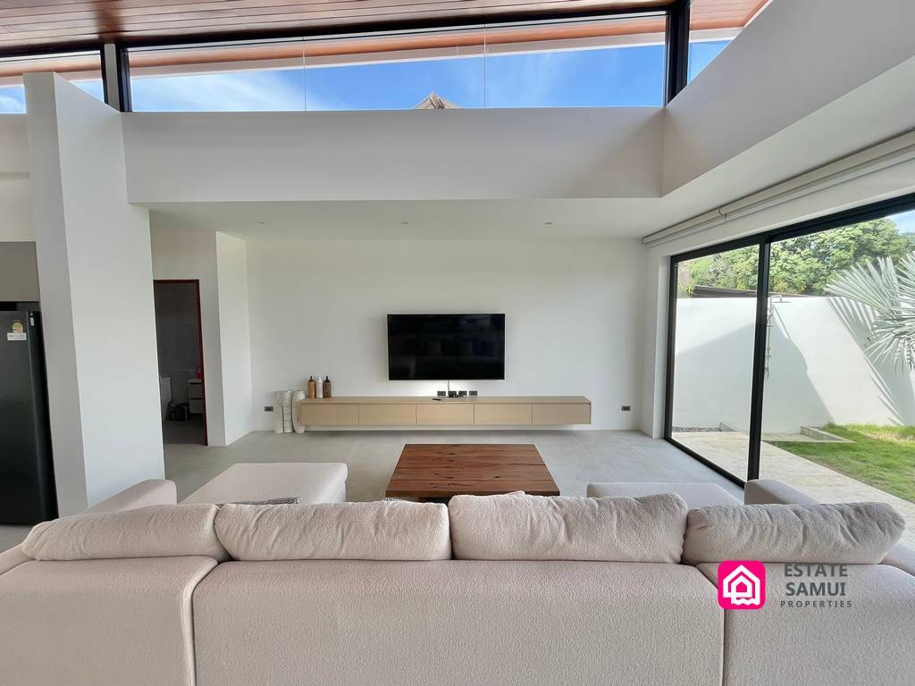 Living room with pale sofa and wall-mounted television