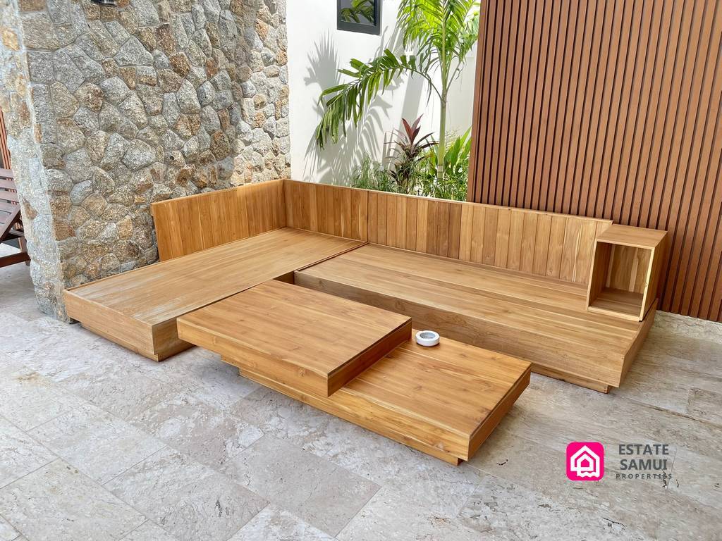 Built-in wooden terrace seating beside a stone wall
