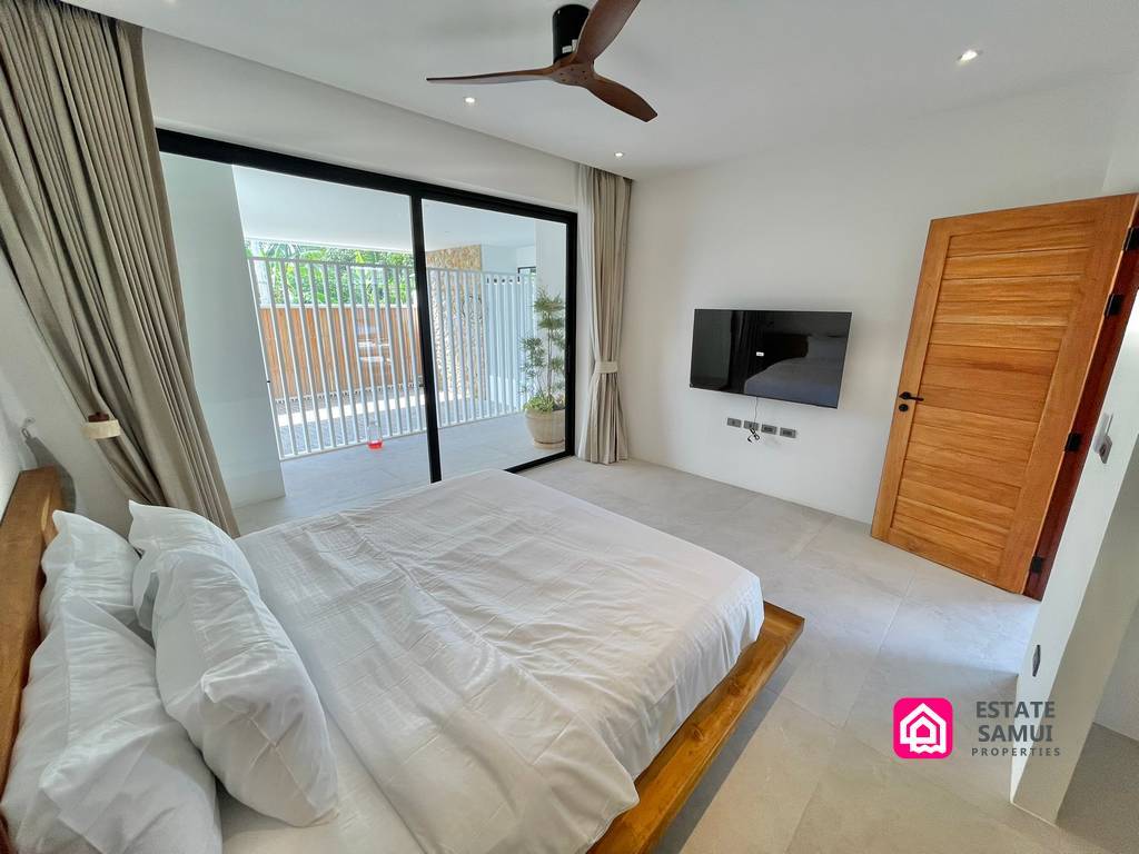 Bedroom with wooden bed and sliding doors to the terrace