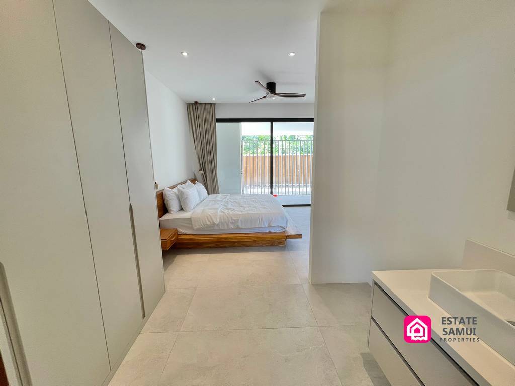 View from the dressing area towards a bright bedroom