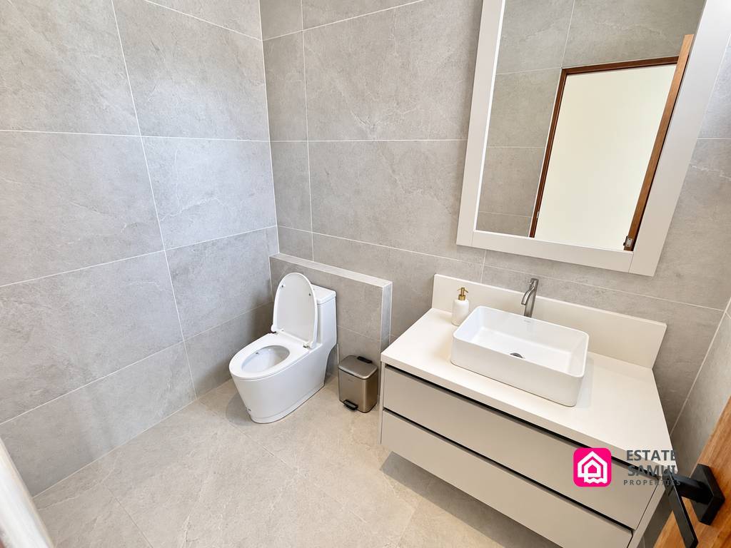 Bathroom with white vanity and grey tiled walls