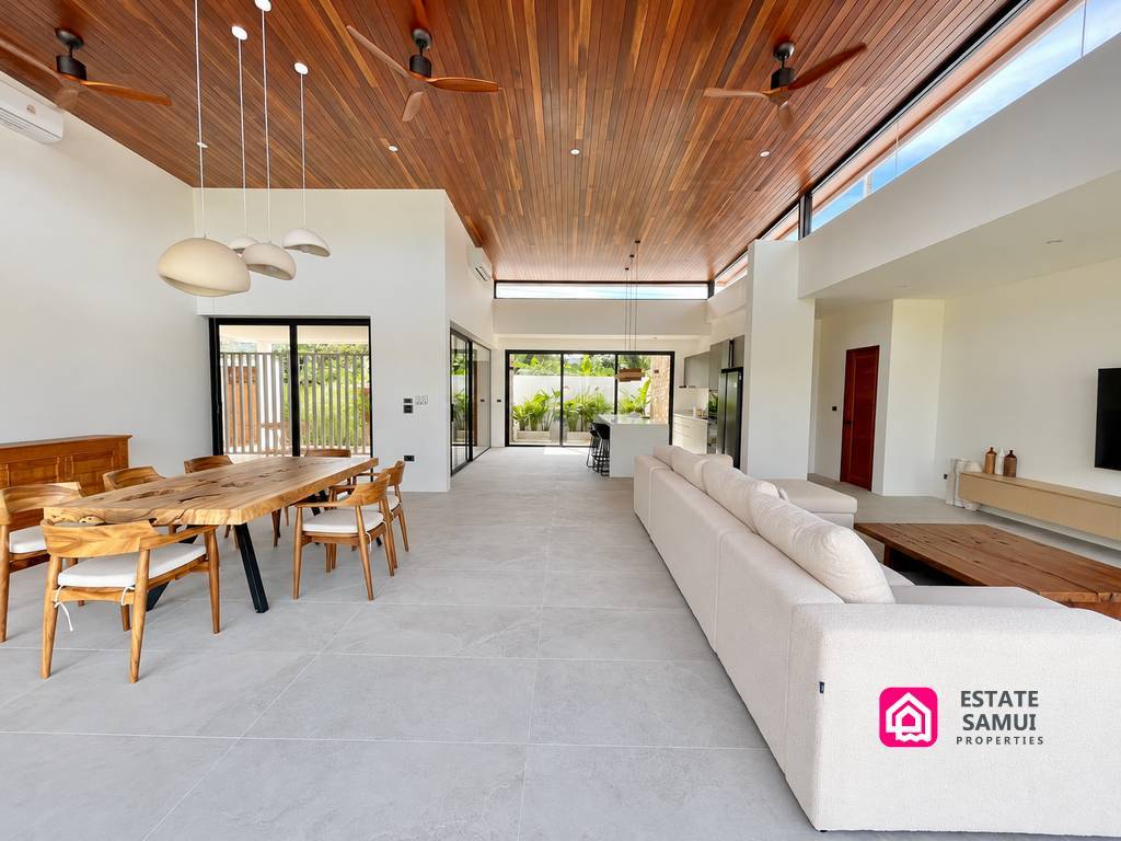 Spacious living and dining area beneath a timber ceiling