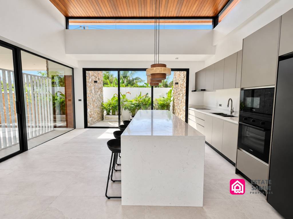 White kitchen island facing glass doors and the garden