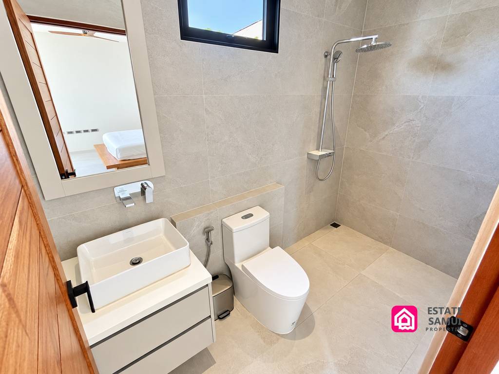 Tiled bathroom with walk-in shower and compact basin