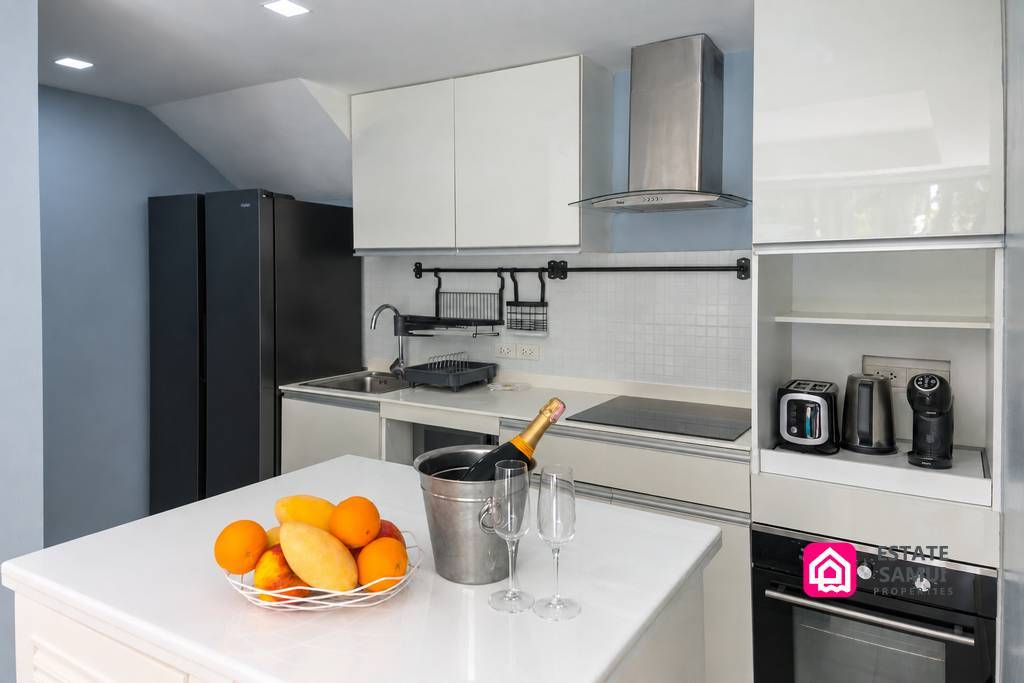 Modern white fitted kitchen with island and integrated appliances