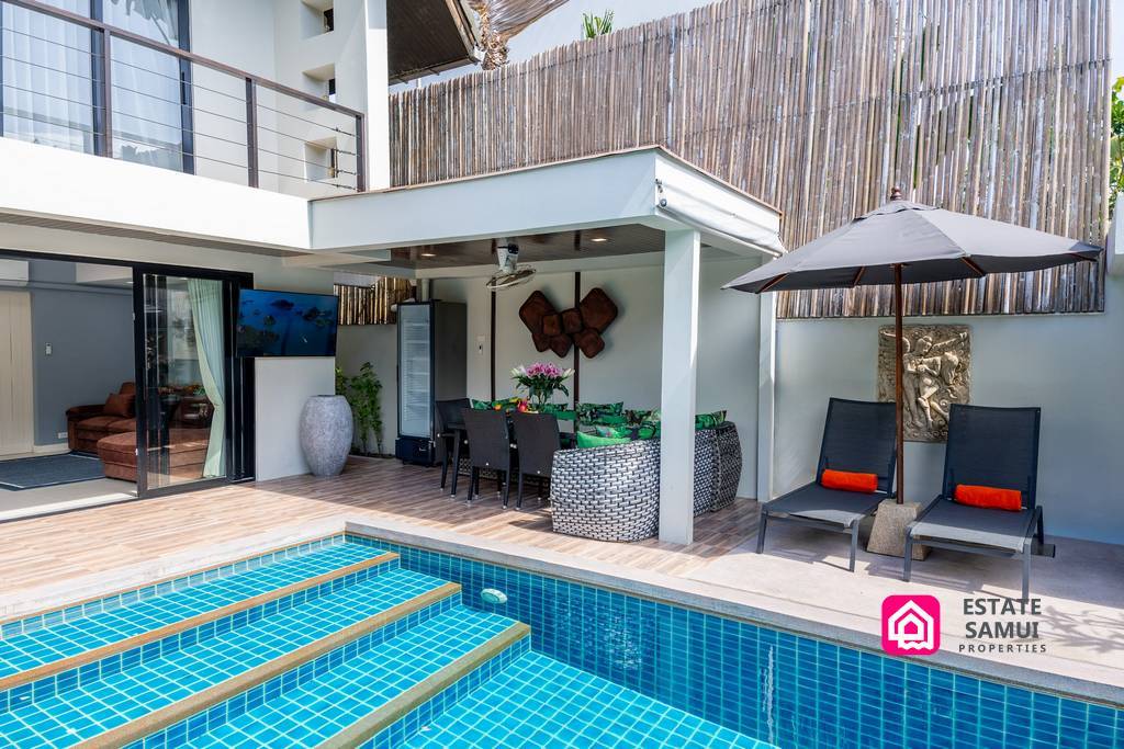 Covered outdoor dining area beside private swimming pool