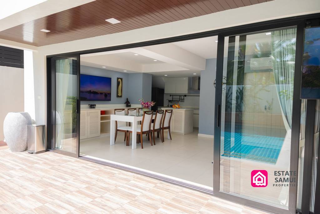 Open sliding doors connecting pool terrace with dining area