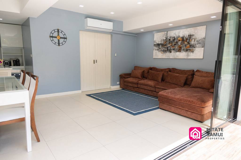 Spacious living area with brown corner sofa and patio access