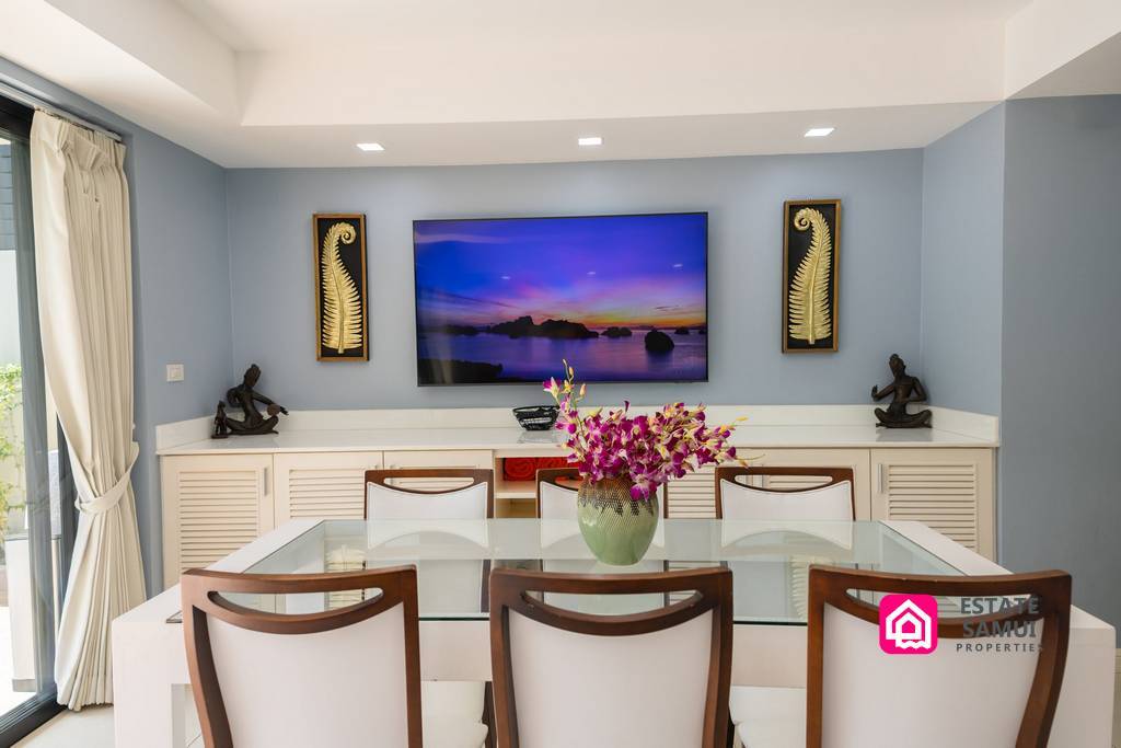 Dining table with floral centrepiece in bright open-plan interior
