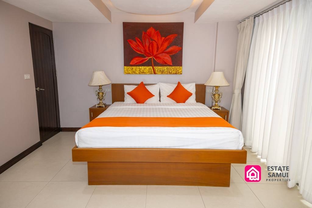 Double bedroom with orange accents and floral wall artwork