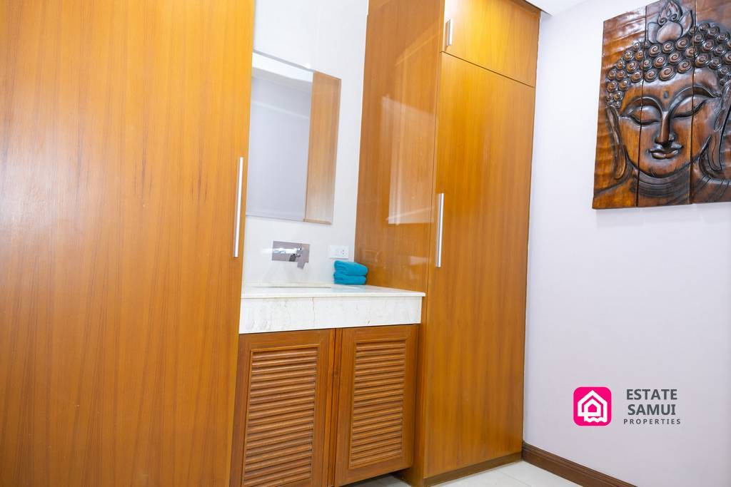 Wooden bathroom vanity and storage with decorative Buddha wall art