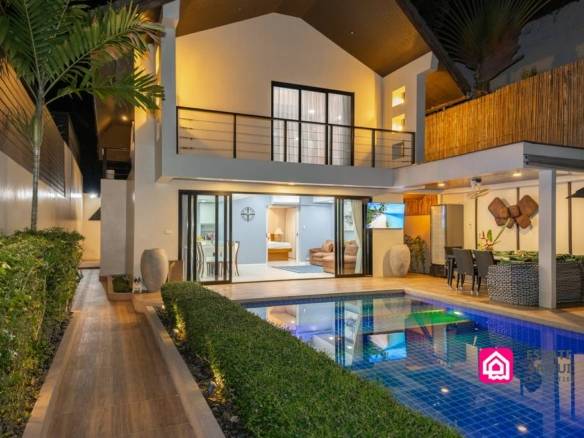 Beachside pool villa illuminated at night beside private swimming pool