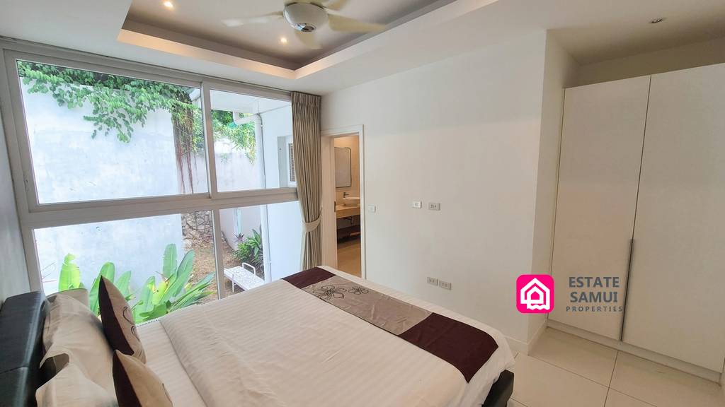 Guest bedroom with fitted wardrobe and garden-facing windows
