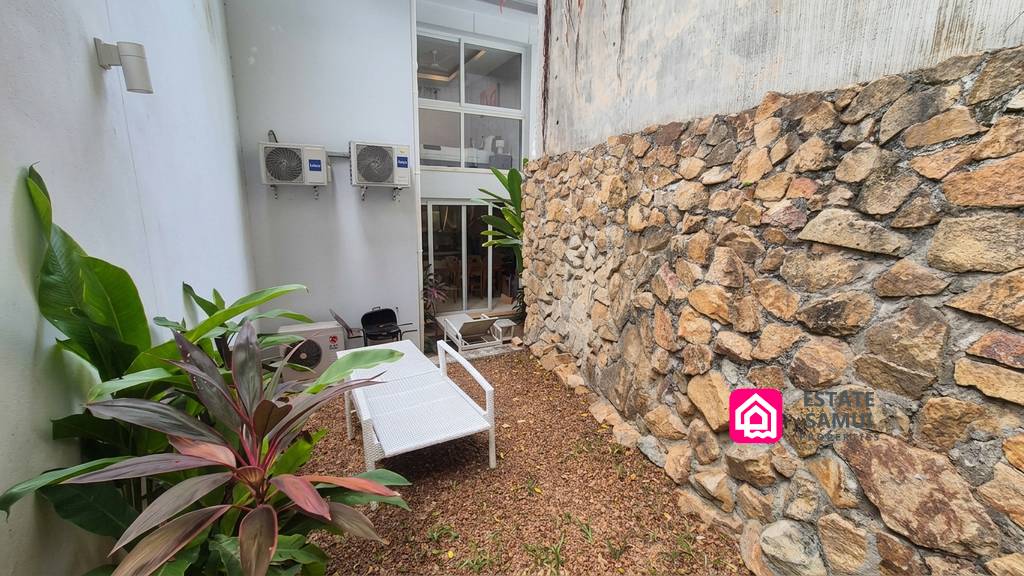 Enclosed garden area with natural stone wall and loungers