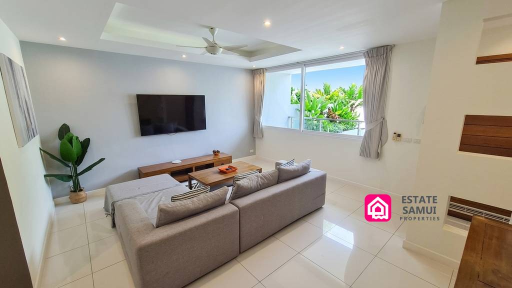 Bright furnished living room with large windows and sectional sofa
