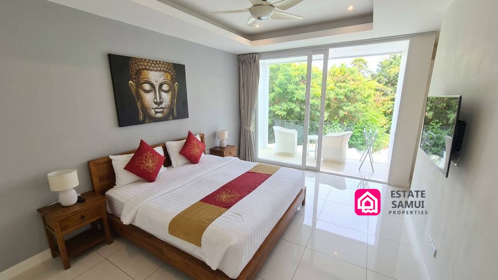 Main bedroom with balcony access and garden views