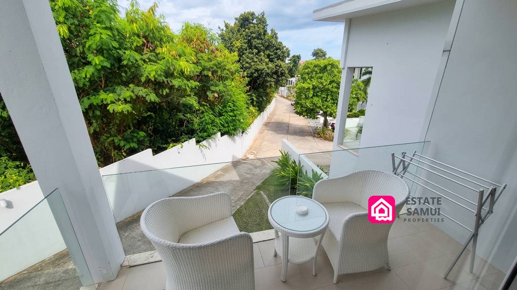 Furnished private balcony overlooking landscaped residential grounds