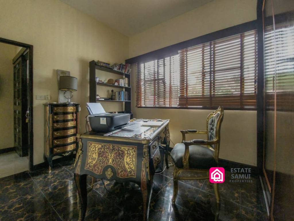 Dedicated home office with ornate desk and wooden window blinds