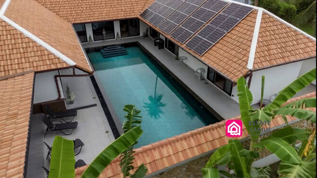 Peaceful pool villa courtyard with solar panels and tropical greenery