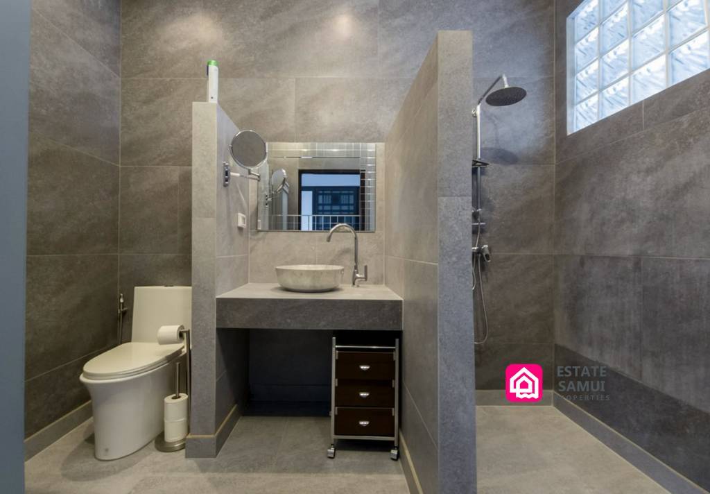 Grey-tiled bathroom with walk-in shower and vessel basin