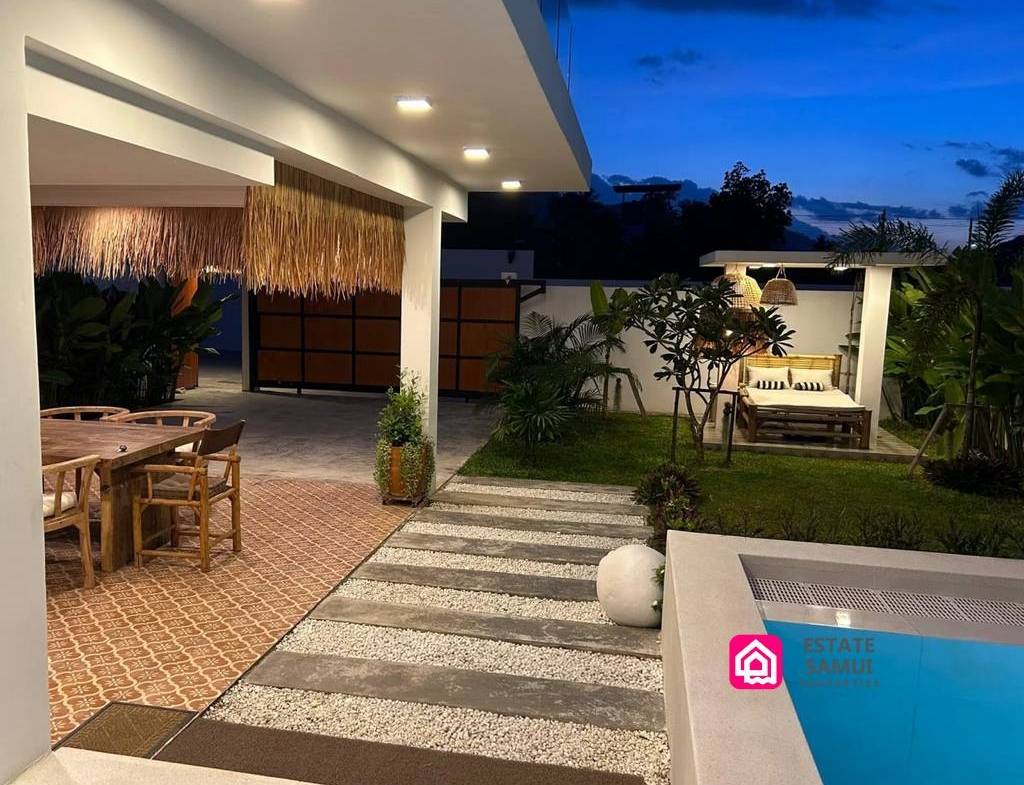 Poolside walkway, garden and covered outdoor dining area at dusk