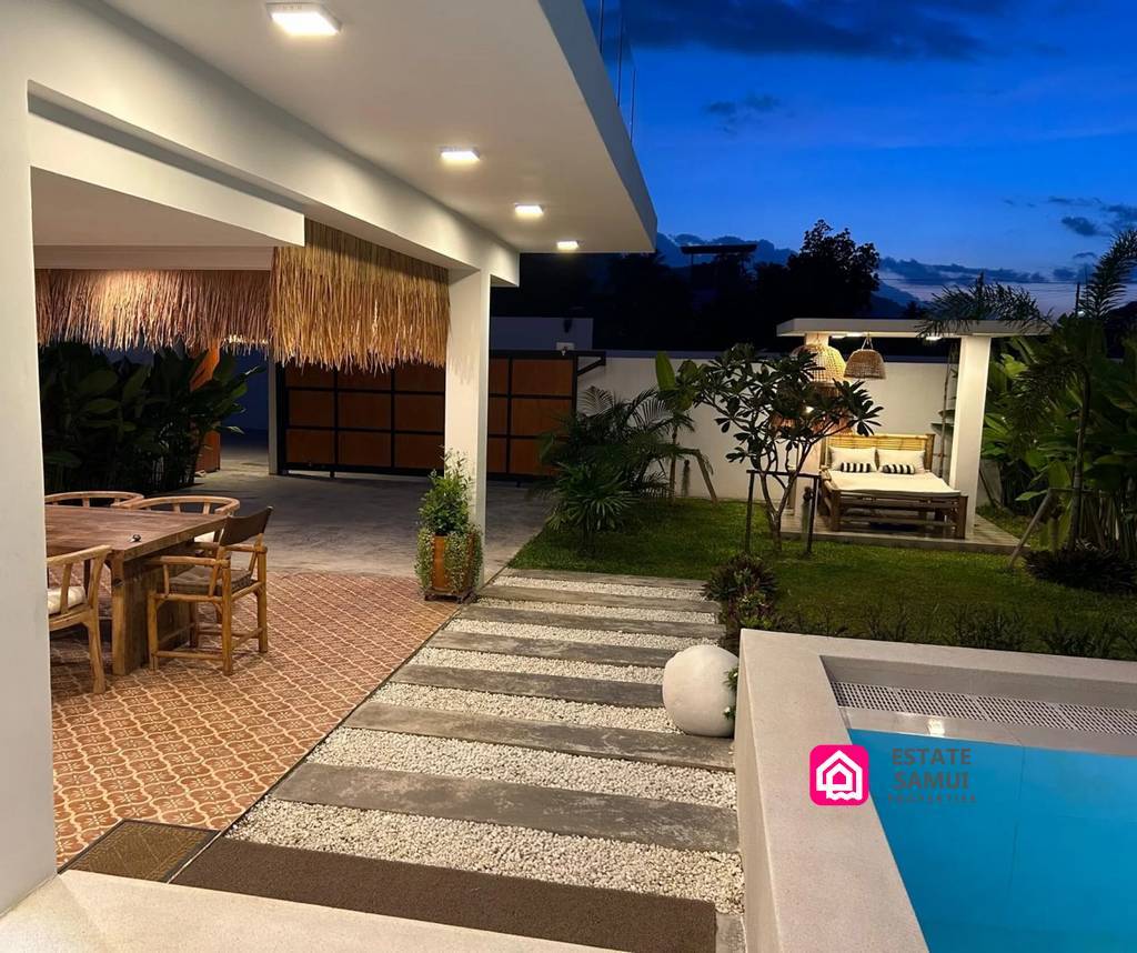 Poolside walkway, garden and covered outdoor dining area at dusk