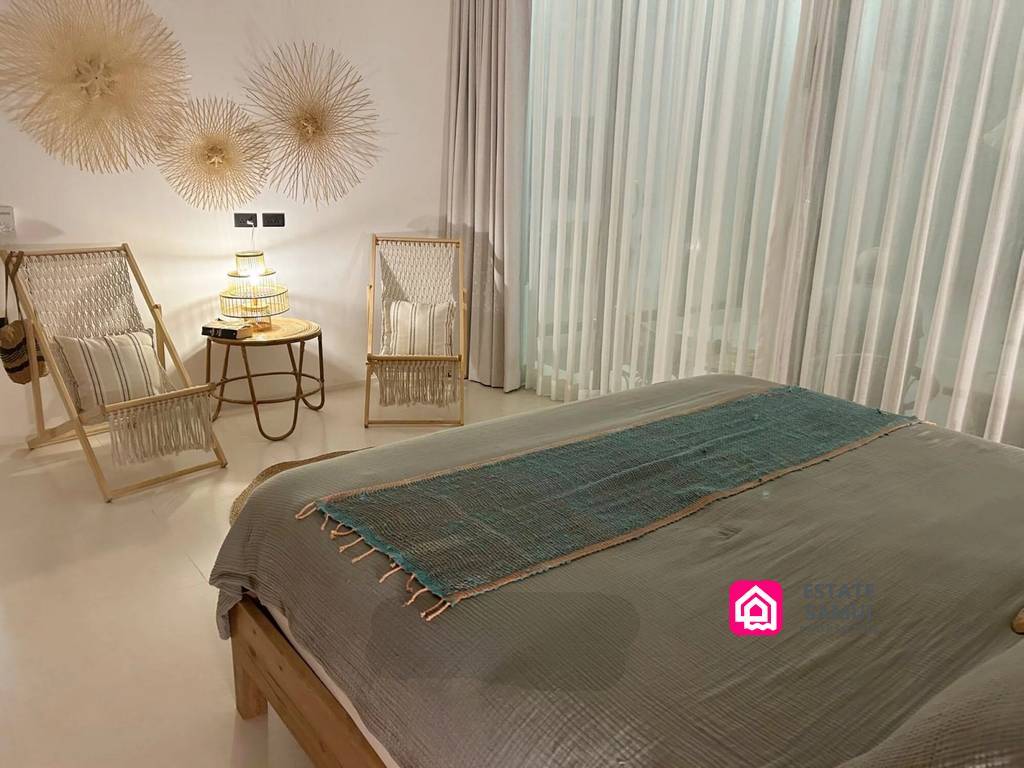 Bedroom with woven chairs and full-height curtains