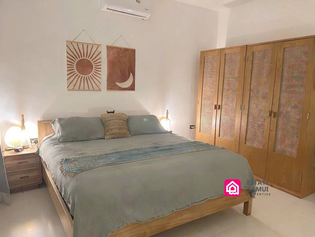 Bedroom with timber wardrobe, bedside lamps and wall art