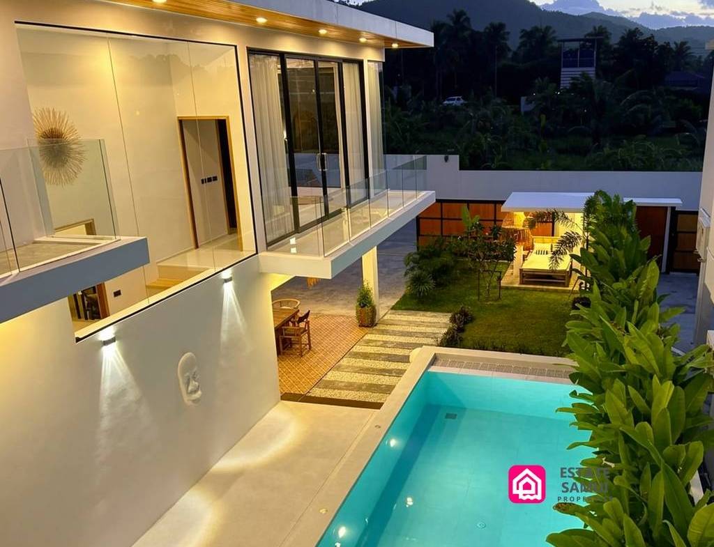 Two-storey villa overlooking the illuminated pool at dusk