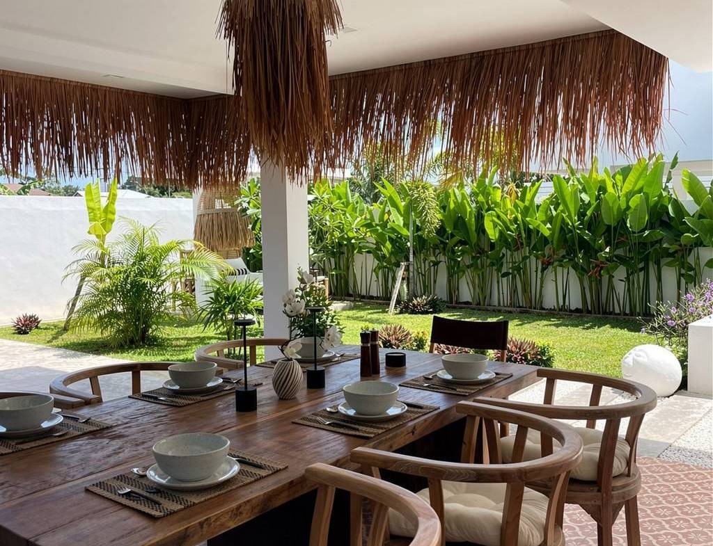 Covered outdoor dining table beside the garden
