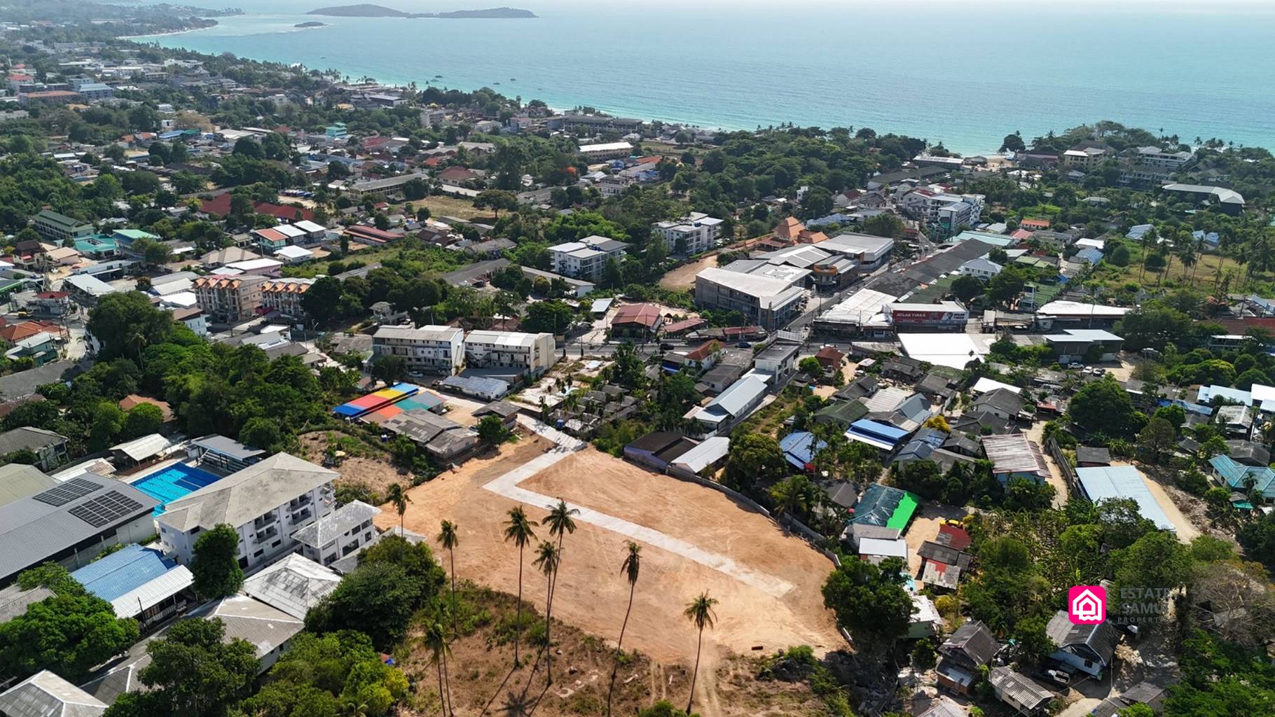 Spacious Chaweng Land for Sale | 7 Plots, Koh Samui Cleared subdivision with concrete access road, surrounding neighbourhood and coastline beyond.