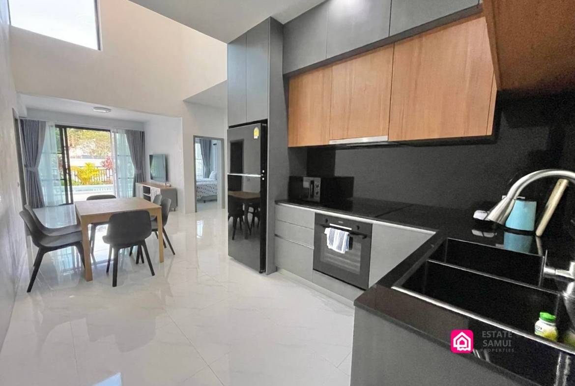 Western kitchen with grey cabinetry and dining area in this contemporary Maenam pool villa.