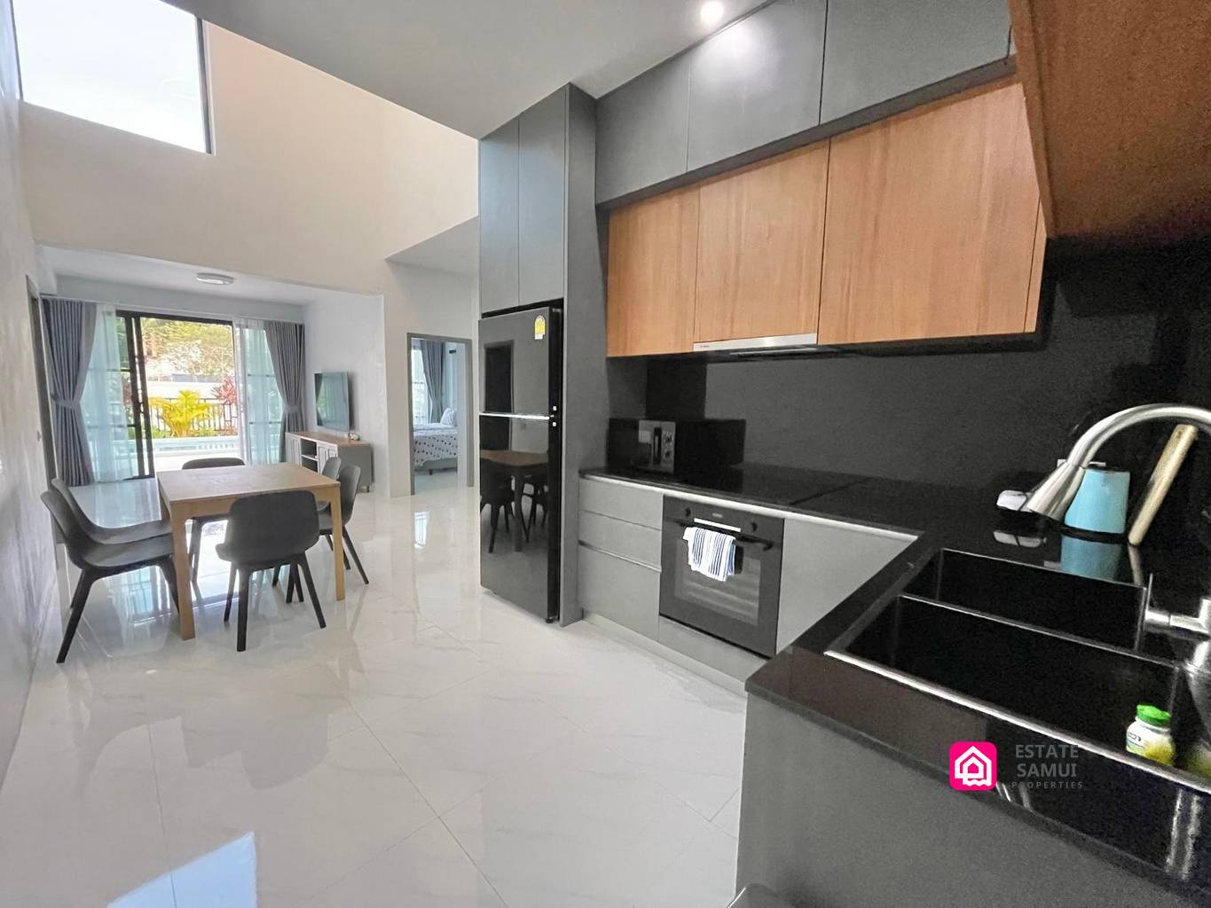 Western kitchen with grey cabinetry and dining area in this contemporary Maenam pool villa.
