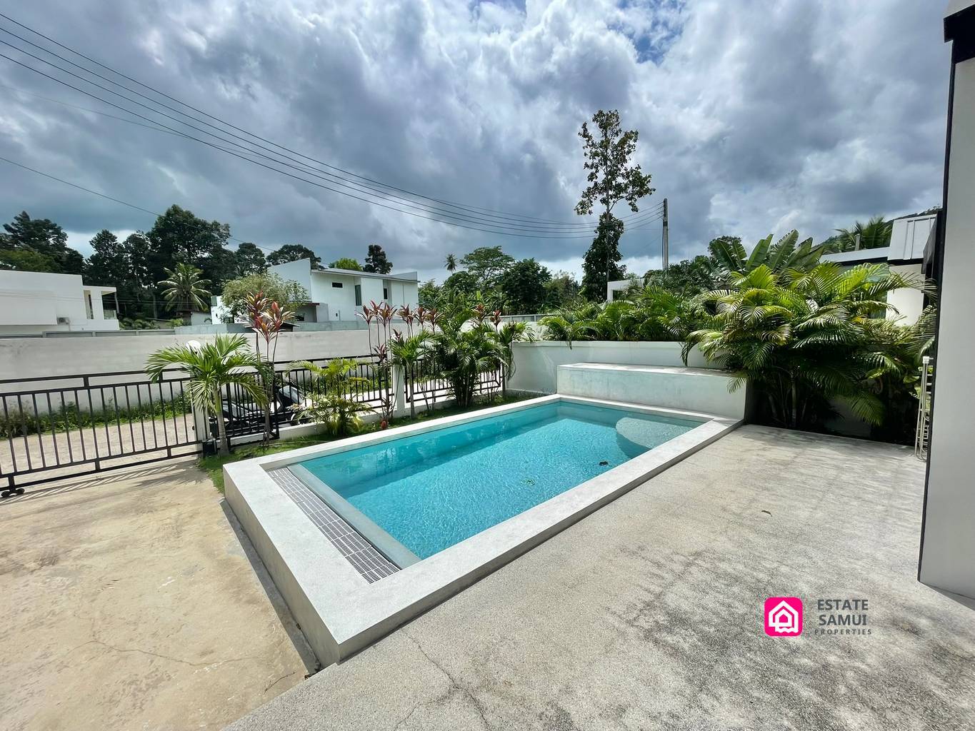 Poolside terrace overlooking the private swimming pool and planted garden borders.