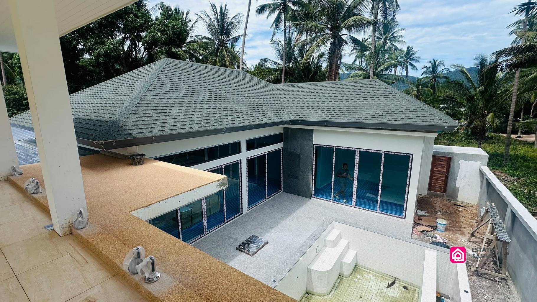 Elevated view of Maenam villa construction with tiled pool and surrounding coconut palms.