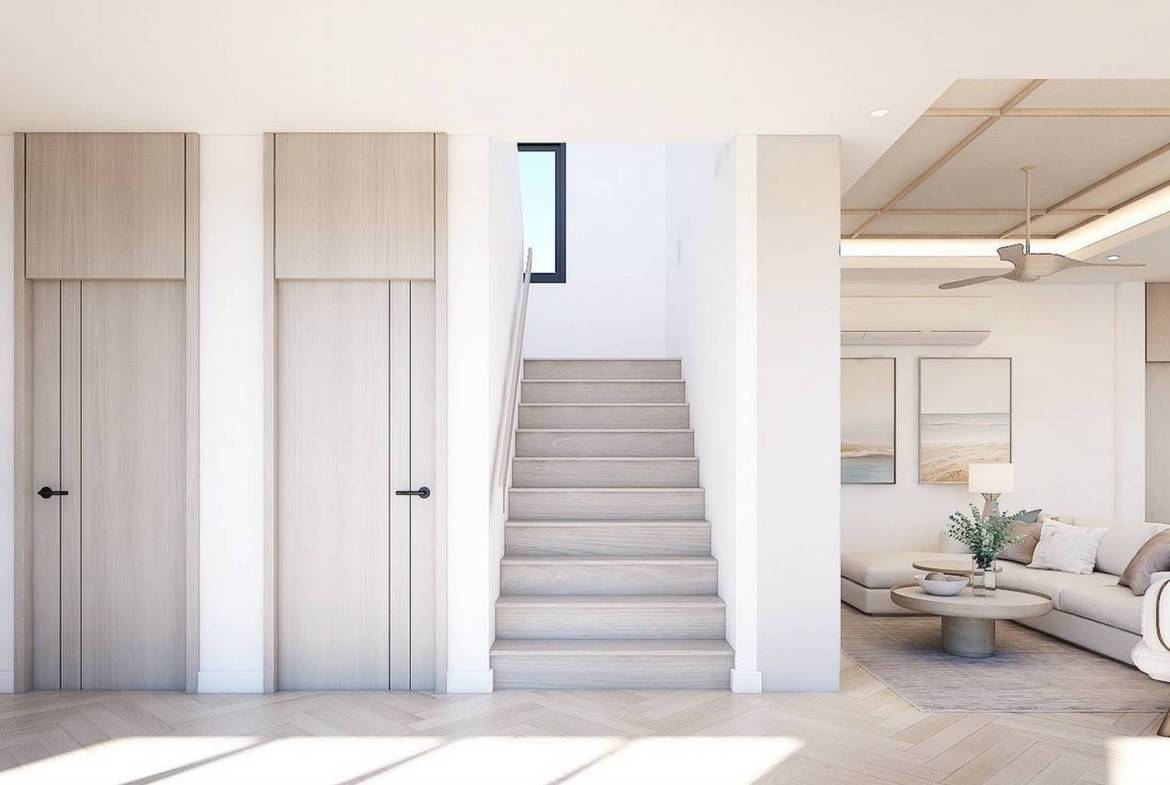 Interior staircase beside built-in cabinetry and open living area