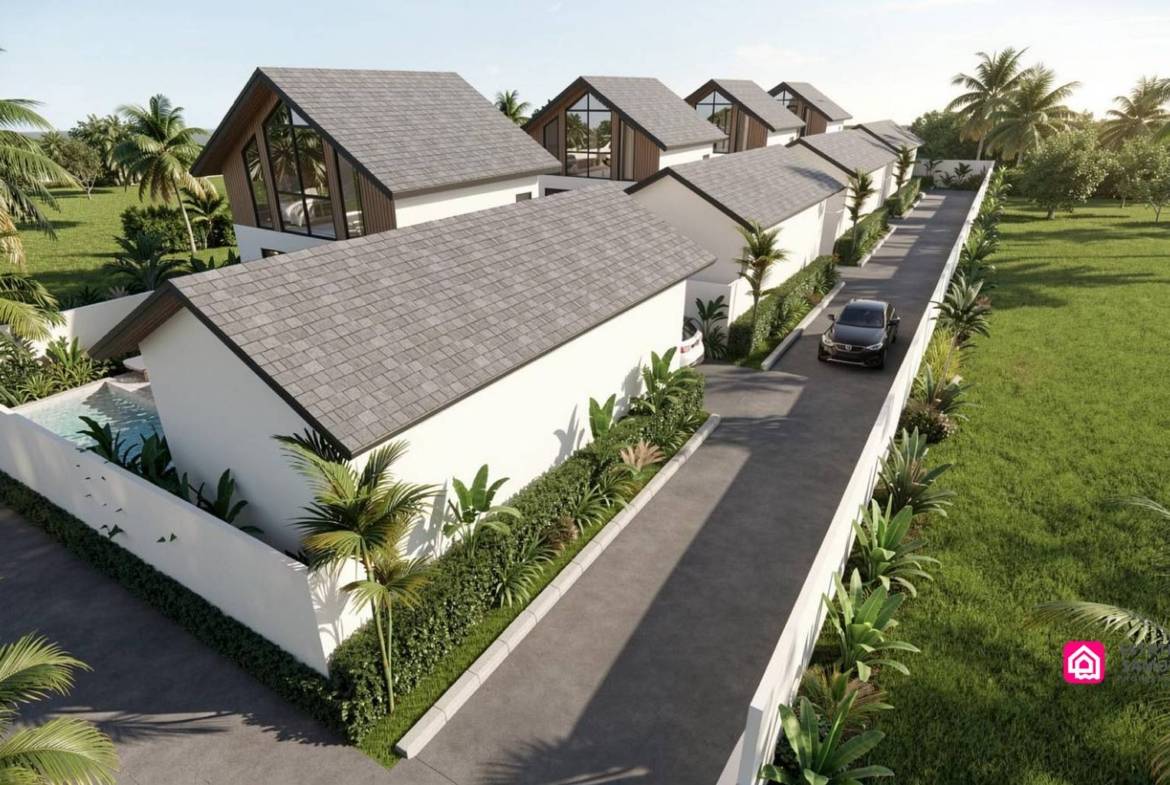 Aerial view of pitched-roof villas and parking along an internal access road.