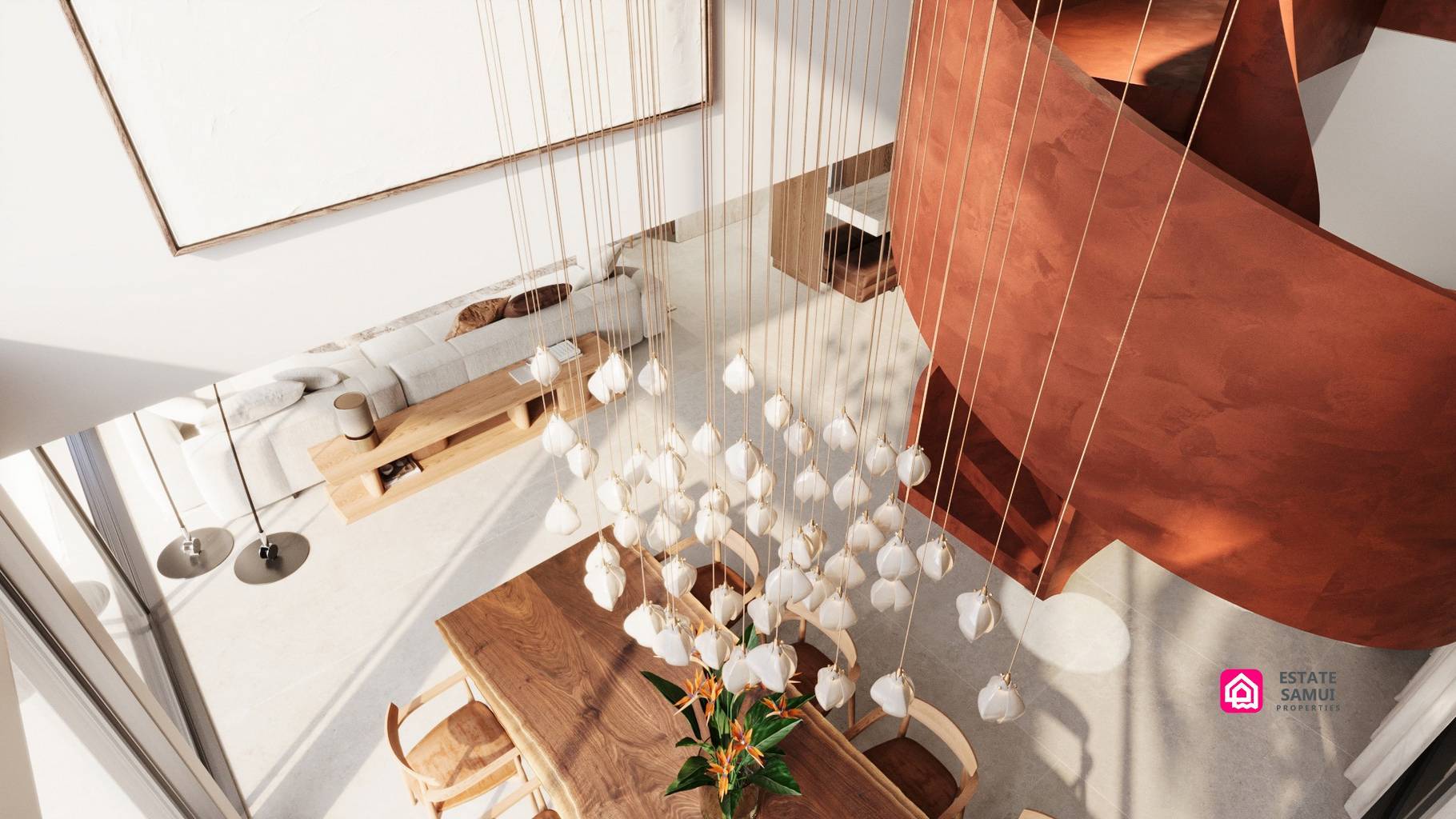 Pendant chandelier above wooden dining table beside curved red staircase.