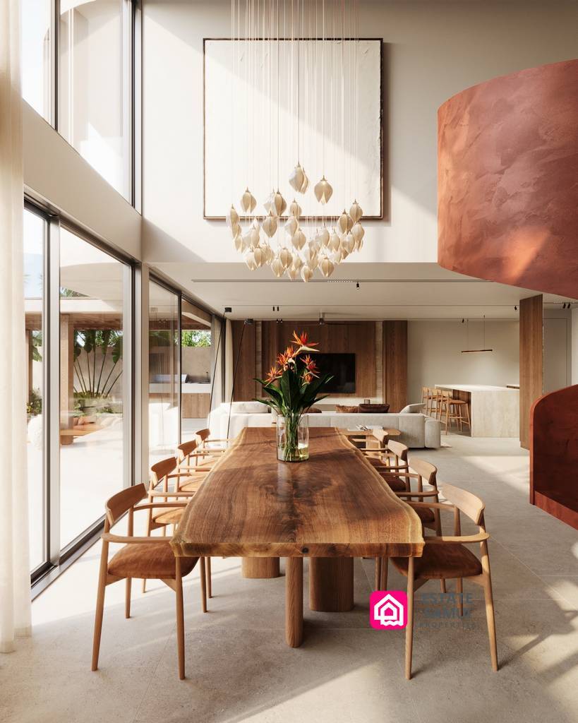 Double-height dining area with wooden table and cascading pendant chandelier.